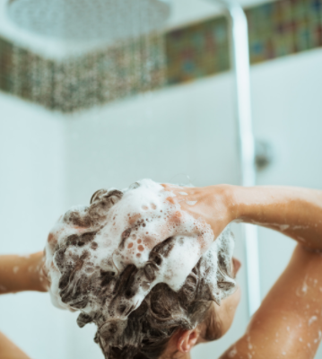 Woman washing her hair with shower head
